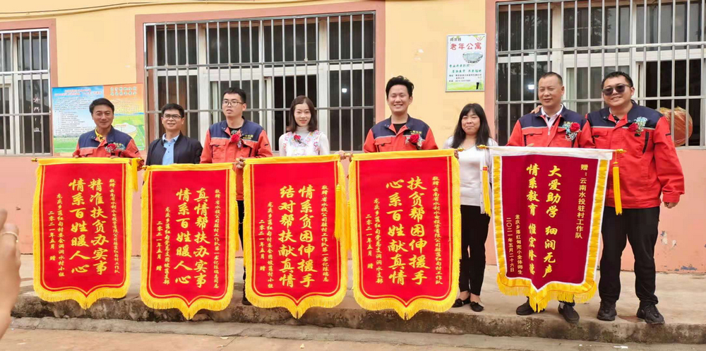 老隊(duì)員手捧落紅甸村各界人士贈(zèng)送錦旗合照.jpg